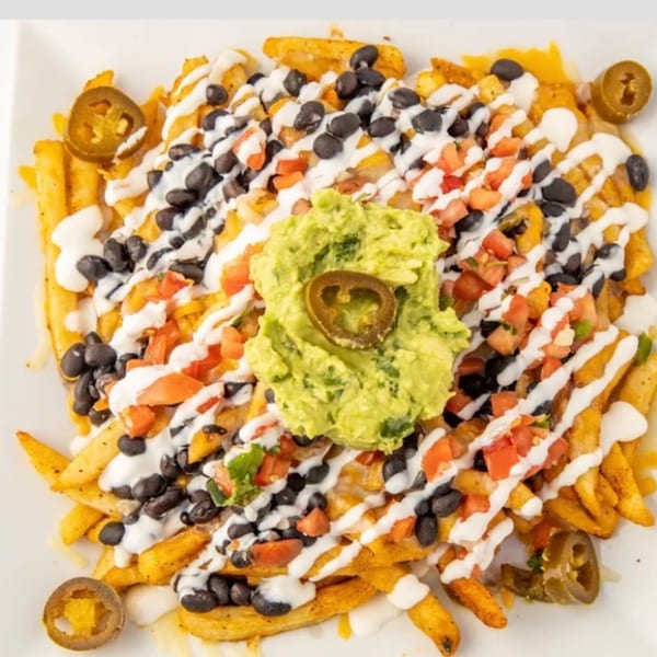 Fat Fish Taco's loaded fries with black beans, tomatoes, sour cream, guacamole, and jalapeños.